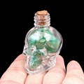 Mini-Glasschädel-Flasche mit grünen Aventurin-Kristallen und Korken in der Hand - Grüner Aventurin