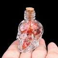 Flacon tête de mort en verre rempli d'agate rouge et bouchon en liège, vue en main - Agate rouge