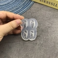 Macro view of translucent silicone nail mold with four unique 3D bow and ribbon designs - 125-Bow-knot
