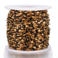 Macro shot of gold-plated stainless steel chain with black enamel beads on a white spool - Gold-Black