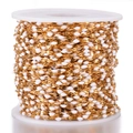 Macro detail of gold plated stainless steel chain roll with white enamel beads for DIY - Gold-White