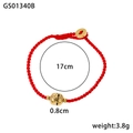 Detail eines roten geflochtenen Armbands mit goldener Hohlperle und Glücksmünzenanhänger - Hohlperle und Münzanhänger (GS01340B)