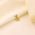 Vue détaillée du pendentif lettre I en métal doré évidé sur un tissu en soie blanche - Lettre évidée I