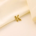 Pendentif lettre K ajouré en acier inoxydable doré sur tissu crème texturé doux - Lettre évidée K