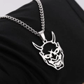 Pendentif masque Hannya en acier inoxydable poli sur fond de tissu noir texturé - Acier
