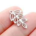 Silver stainless steel hollow leaf charm on fingertip showing small size and details - Steel Color Hollow Leaf (DY750-1)