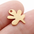Gold stainless steel irregular leaf pendant accessory shown on fingertip for scale - Abstract Organic Shape (DY763-2)