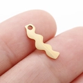 Golden irregular wave pendant in stainless steel shown on fingertip for size reference - Minimalist Zigzag (DY769-2)