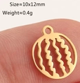 Macro view of a 10x12mm hollow gold fruit pendant charm held on a fingertip - Round Watermelon - Gold (DY1271-2)