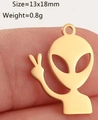 Macro view of golden alien peace sign pendant on fingertip showing 13x18mm size - Gold Alien (DY1285-2)