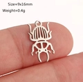 Ciondolo a forma di scarabeo in acciaio inossidabile lucido mostrato su un polpastrello - Forma di Scarafaggio Traforata (DY1367-1 Acciaio)