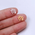 Close-up of gold and silver Virgo zodiac pendants shown on fingertips for size scale - Virgo