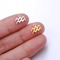 Polished Aquarius zodiac pendants in gold and silver finish shown on fingertips - Aquarius