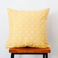 Detail of yellow geometric pillow with white grid pattern on a wooden stool - Yellow Geometric