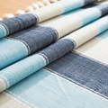 Close-up of waterproof striped linen tablecloth with tassel fringe and geometric blue weave - 120cm x 120cm / Blue & Grey Striped