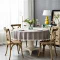 Detail of round gray linen tablecloth with white tassel trim on a wooden dining table - Tassel Decoration / 220cm / Gray