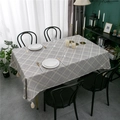 Primer plano del moderno mantel de cuadros grises con borlas decorativas y textura de lino - 90x90cm / Gris