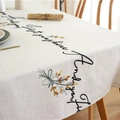 Mantel de lino y algodón beige con texto cursivo negro y bordados de hojas coloridas - 135x100 / Flor Amarilla Café Gris