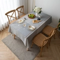Moderne geometrische Tischdecke mit Karomuster und Quasten auf einem Holztisch - Größe Eins / Grau Gestreiftes Gitter