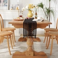 Black lace table runner with hollow geometric patterns and elegant tassels on a wooden table - 24x140 / Black