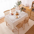 Nappe élégante en dentelle florale beige avec motifs évidés sur une table en bois - 60x60cm / Blanc Cassé (Fleur de Prunier à Boucles)