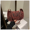 Détail du sac baguette imprimé léopard rouge avec fermeture éclair dorée élégante - Rouge