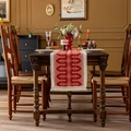 Vintage jacquard table runner with red floral patterns and tassel trim on wooden table - Red Chain