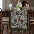 Camino de mesa jacquard con bordado floral y borlas verdes sobre mesa de madera - Borde Verde Flor Dorada Con Borlas Verdes / 35x120