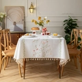 Rectangle cream floral embroidered tablecloth with tassels in a cozy dining setting - Embroidered Secret Garden Pink + Cotton Tassels