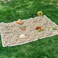 Vintage floral woven picnic mat with white fringe tassels on green grass lawn - Beige Floral + Dense Tassels