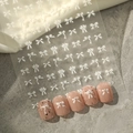 Nahaufnahme von YT487 weißen Schleifen-Nagelstickern mit Perlen auf rosa Kunstnägeln - Weiß Flach (YT487-2)