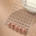 Detail von süßen schwarzen Schleifen- und Herz-Nagelstickern auf rosa künstlichen Nägeln - Schwarz Flach (YT490-1)