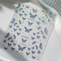 Detalle de pegatinas de uñas de mariposa azul en 3D con estrellas púrpuras en bandeja blanca - Pegatina Mariposa Azul