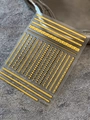 Goldene Nageltattoo-Aufkleber im Boho-Stil mit geometrischen Mustern auf grauem Stein - Goldfilm Yt6747hj