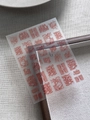 Detail view of reddish-brown nail art stickers with abstract textures on a gray fabric - Red Brown Abstract Art Texture (YT6381Pm)