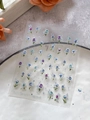 Detail view of 3D embossed rose nail stickers with silver stars on a ceramic plate - Silver Laser Style (YT6425)