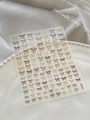 Macro detail of 3D bow nail stickers in vintage earth tones on pearl display tray - Embossed Maillard Color Style (YT6248)
