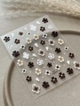 Detail van 5D-embossed bloemen nagelstickers in bruin en crème op keramische schaal - Gelei (YT6795) / Maillard Stijl