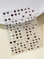 Macro shot of YT5814 heart-shaped nail art stickers on beige leather texture - Dark Silver Edge Heart (YT5814Si)
