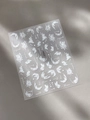 Macro shot of white embossed floral nail stickers with garden text on grey leather background - Embossed White Floral (YT5254)