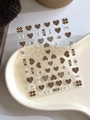 Detail showing 3D embossed heart and bow nail art stickers in cream and brown on a tray - Relief YT4210 (Brown White Heart Bowknot)