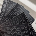 Assorted nail art stickers featuring silver moon, stars, and butterflies on black sheets - Spray Painted Sticker
