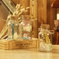 Tres botellas de deseos de cristal con corchos, flores secas y rollos en madera - Botella Flash de Flores Secas