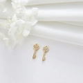 Detailed view of heart-shaped gold key pendants with white zircon pavé on white fabric - Heart Key Style (H-8646)