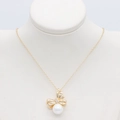 Detailed view of a gold bow pendant with micro-diamonds and a round white pearl - Bow Pearl Pendant (S-0147)