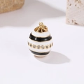 Macro view of a 14k gold white enamel egg pendant with black stripes and zircon inlay - Black Stripe