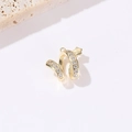 Detail eines goldenen Ear Cuffs mit Zirkonia und Sternmotiv auf neutralem Steinhintergrund - Spiralstern Stil (H-9310) / 14K-Gold