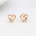Detail of gold heart-shaped clip-on earrings with hollow crossed lines and soft silicone pads - Gold Hollow Heart Style (N-0117)