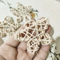 Close-up of hand holding natural cream-colored rattan stars for bird foot toys - 6.5CM Pentagram (Natural Color)