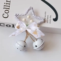 Detail of silver star ornament with printed white ribbon and festive white metal bells - White
